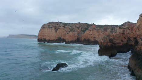 Luftdrohne,-Die-über-Dem-Atlantik-Fliegt,-Zeigt-Malerische-Farbige-Felsenklippenküste-In-Lagos,-Algarve,-Portugal