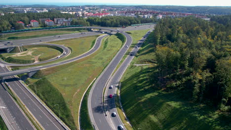 Toma-Aérea-Hacia-Atrás-De-Un-Gran-Cruce-En-Gdynia-Con-Vías-De-Intercambio-De-Pasos-Elevados-Y-Subterráneos