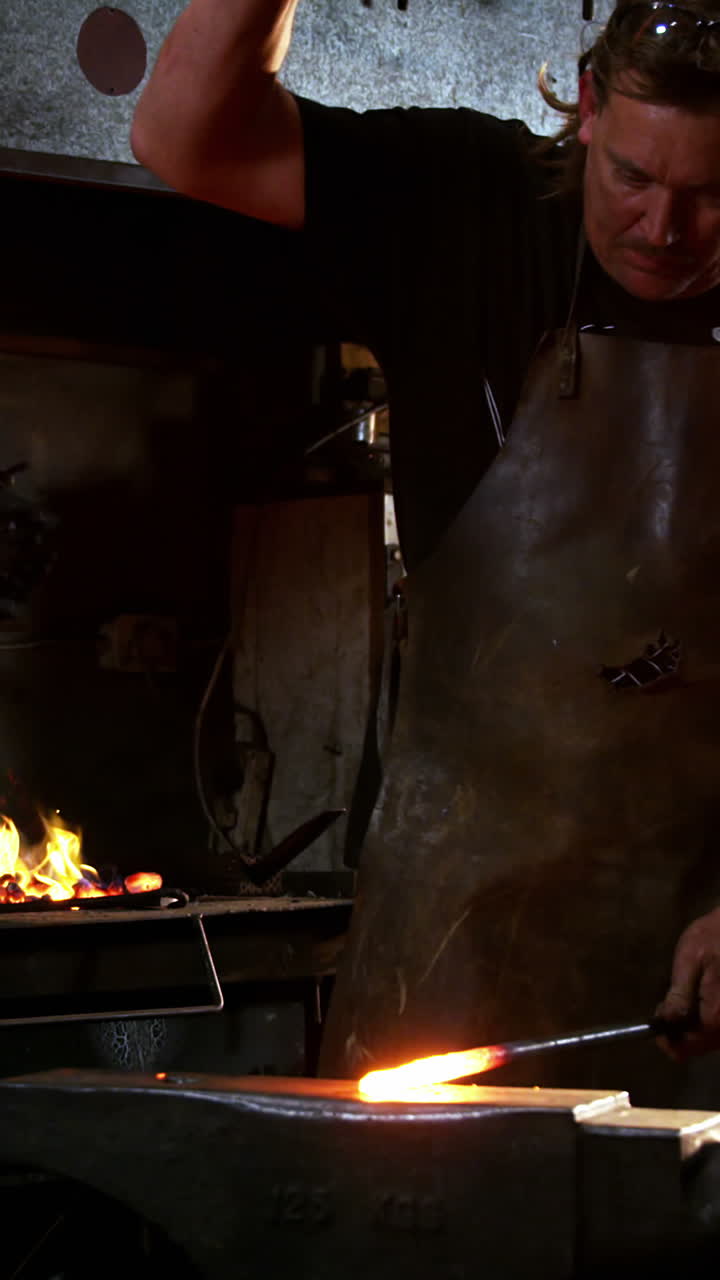 herrero trabajando en una barra de hierro