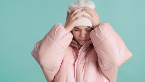 teenage caucasian girl with winter clothes making faces in front of the camera.