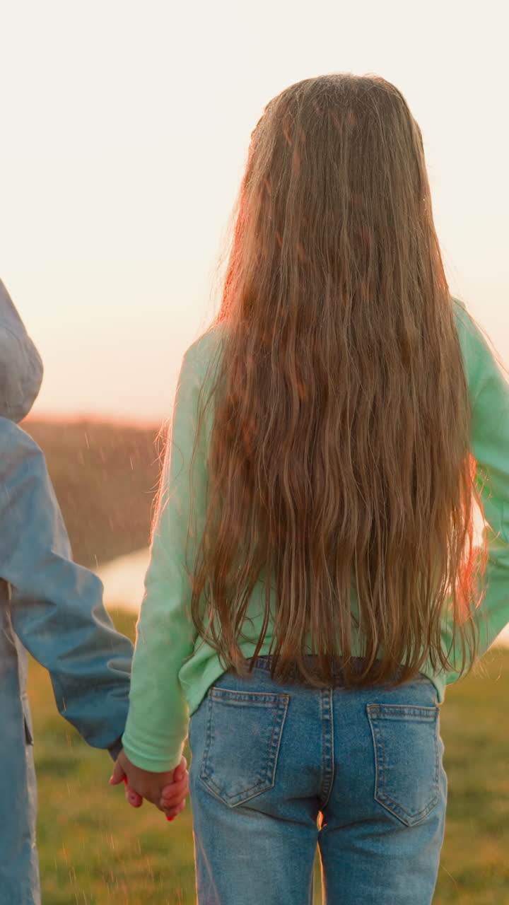 어린 소년과 소녀는 시골에서 비가 오는 동안 손을 잡고, 유아 형제와 유치원 자매는 따뜻한 봄 폭풍에 걸어가는 조용한 강을 바라보고, 비가 오는 자연의 아름다움.