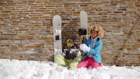 snowboarding friends sitting in pile of snow