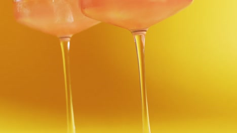 close up of drink with cherry on yellow background