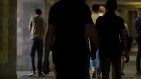 people walking in a dark underground passageway