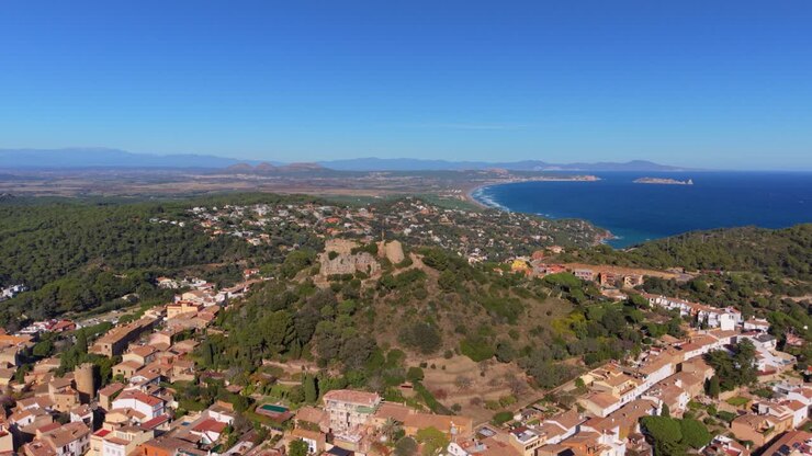 Maestosa vista aerea della città storica di Begur, il suo castello medievale e la splendida costa mediterranea della Costa Brava, Catalogna, in una bellissima giornata di sole con cielo azzurro.