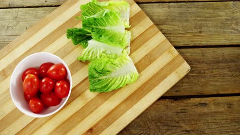 Lettuce-and-tomatoes-in-bowl-on-chopping-board