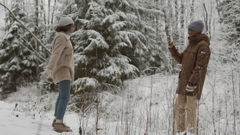 couple taking picture in a snowy forest