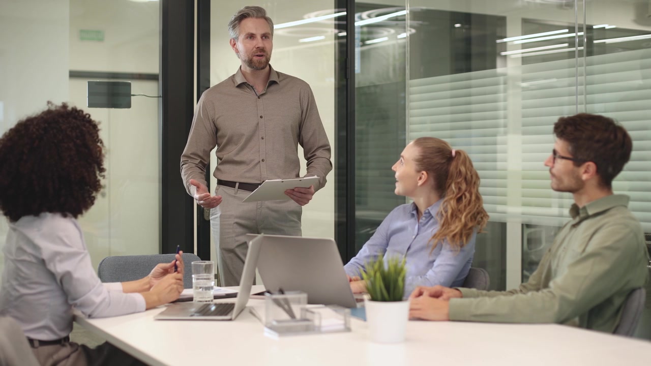 Manager Presenting Charts to Diverse Team in Office Meeting