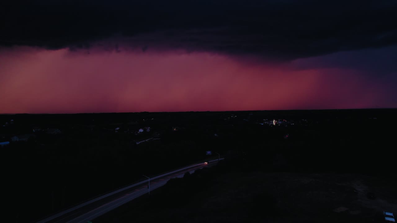A lightning bolt strikes near a small town, highlighting the vulnerability of isolated communities in the face of extreme weather. Minnesota, USA