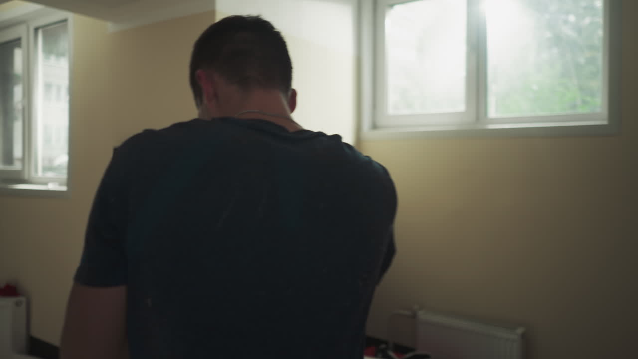 권투 장갑을 입은 남성 선수는 지하실에서 트레이너의 감독 하에 전문적인 치를 개발합니다.