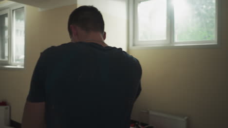 male athlete in boxing gloves develops professional punches under supervision of trainer in basement. practicing professional sports in equipped basement