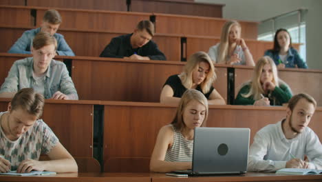 Large-Group-of-Multi-Ethnic-Students-Working-on-the-Laptops-while-Listening-to-a-Lecture-in-the-Modern-Classroom.-Bright-Young-People-Study-at-University.