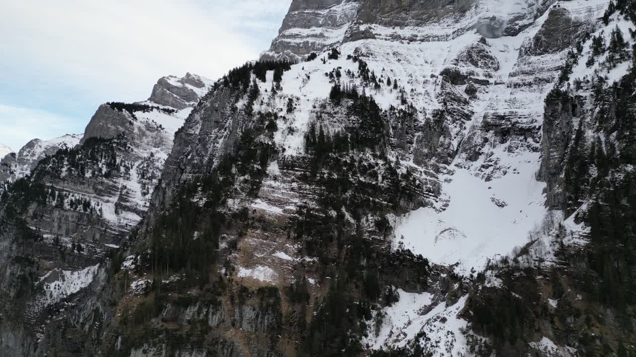 klöntalersee suiza glarus vuelo aéreo inverso para mostrar el tamaño de los acantilados de la ladera de la montaña