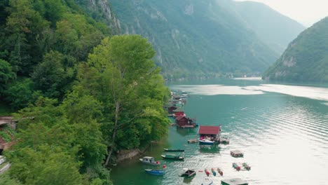 Casas-Flotantes-Del-Lago-Perucac-En-El-Río-Drina,-Serbia-Occidental,-Rodeadas-Por-Un-Valle,-Un-Cañón-Angosto-Y-Un-Bosque---Toma-Aérea-De-Drones