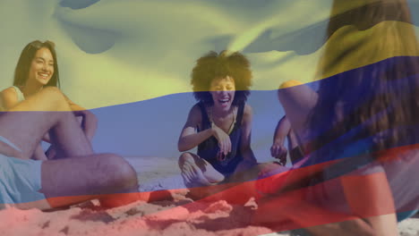 animation of flag of colombia waving over diverse friends enjoying conversation at beach