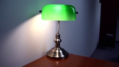 green reading lamp in a hotel room, on a brown desk