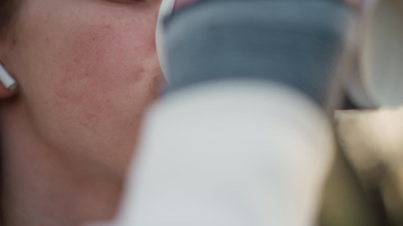 부드러운 광채가 감도는 생각에 잠긴 얼굴, 은은한 주변 조명 속에 잠겨 있는 사색적인 사람의 클로즈업, 헤드폰과 따뜻한 저녁 분위기로 반성적인 분위기를 묘사하는 친밀한 이미지