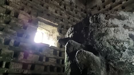 inside old penmon priory dovecot with stone wall nesting box and window light