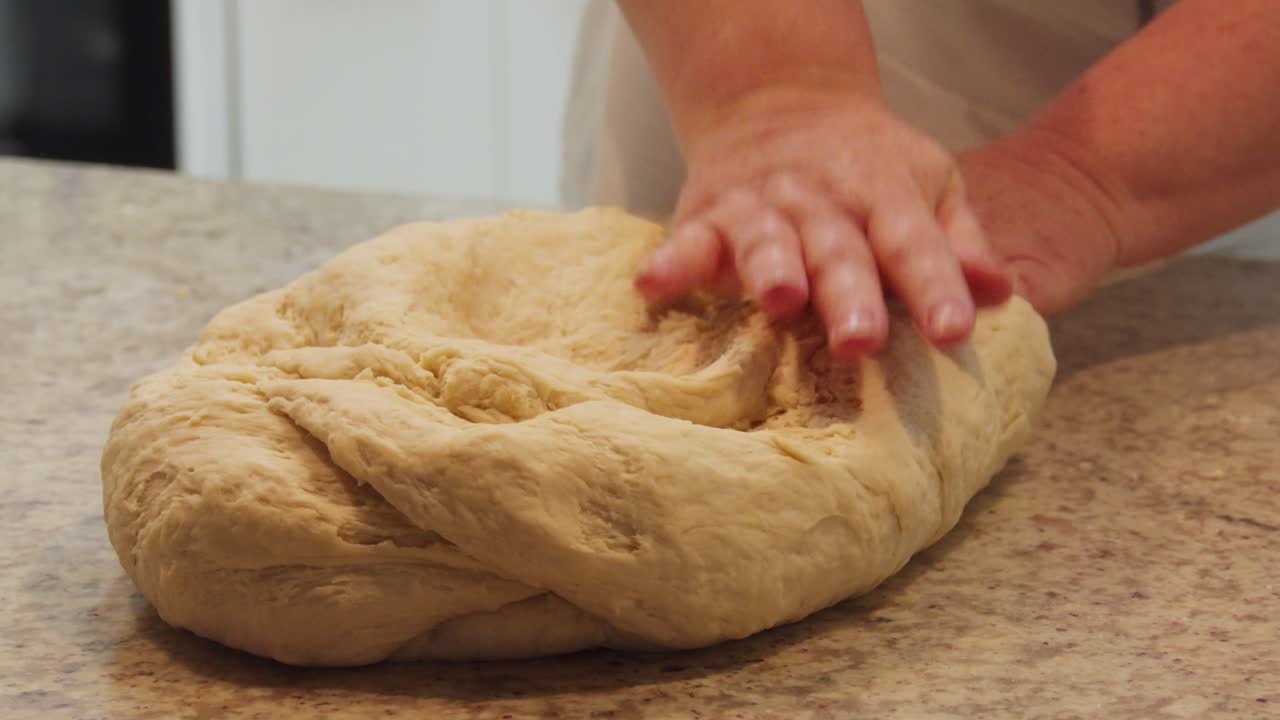 Chef hands kneading a big dough