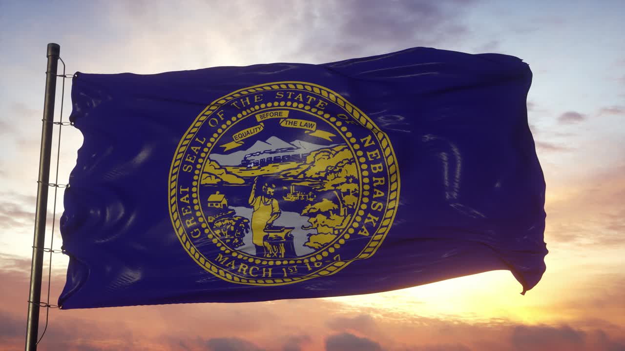 bandera de nebraska ondeando en el viento contra el cielo profundo hermoso al atardecer