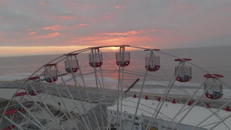 vista de la rueda de ferris de un asombroso amanecer que se levanta sobre el océano