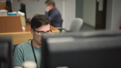 broadcast operator in control room, focused on monitors and desk equipment. engaged in live broadcast operations, adjusting settings and overseeing production process, professional media environment