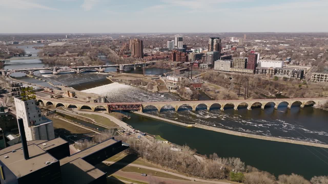Minneapolis şehir merkezinde, Mississippi Nehri üzerindeki ikonik Taş Kemer Köprü'nün muhteşem şehir manzarasıyla çevrili drone çekimleri.