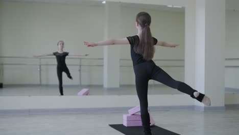 young ballet girl at studio lesson. training performance. stretching exercise pose. ballerina practice balance technique. classical elegance fitness.