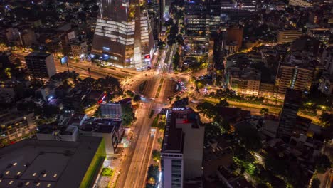 aerial orbit of manacar tower roundabout night traffic in mexico city, timelapse