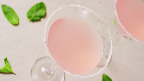 close up of drinks with sugar over basil on white table