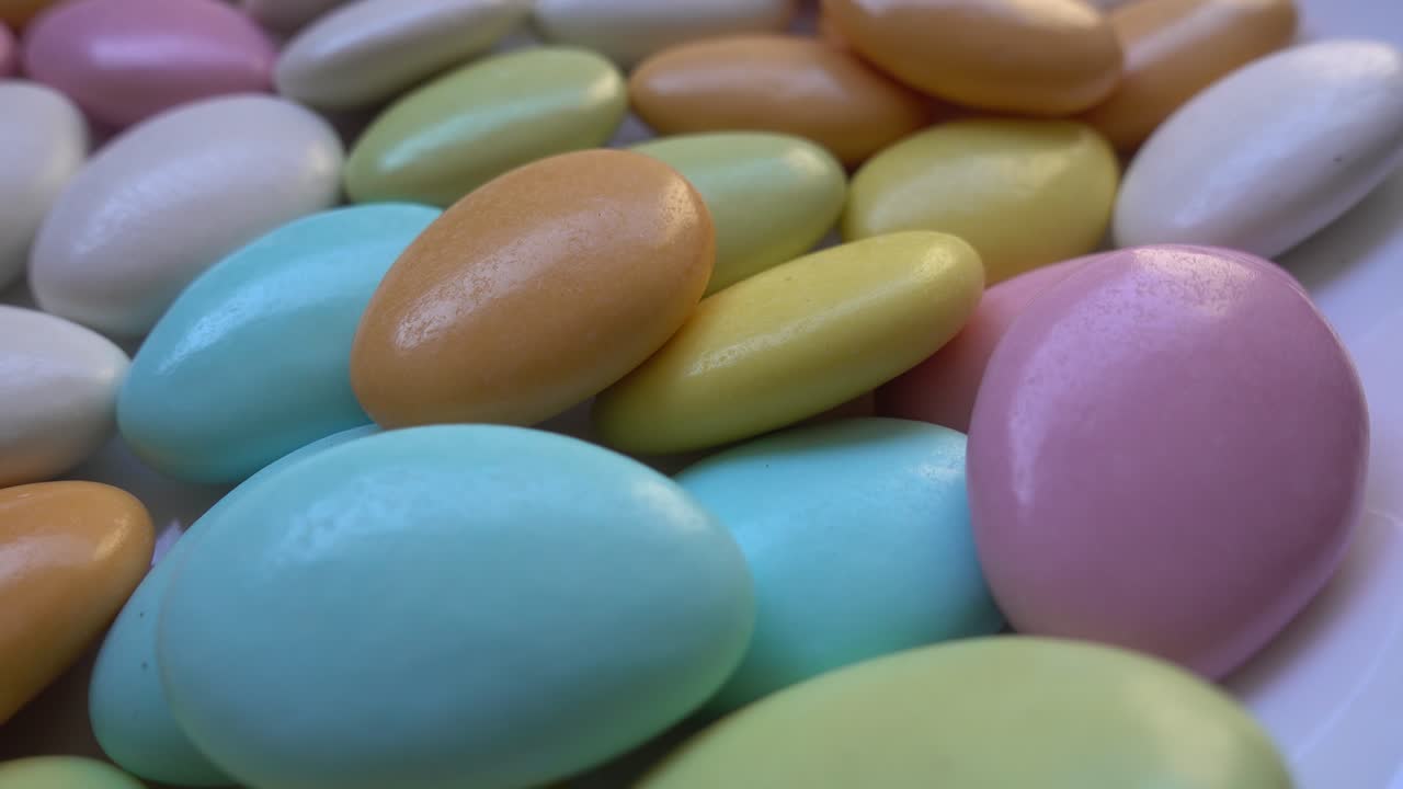 Pile of chocolate-covered almonds or colored pine nut almonds. Easter season