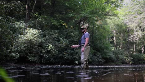 slow motion footage at water-level of a fly fisherman in the pocono mountains in pennsylvania