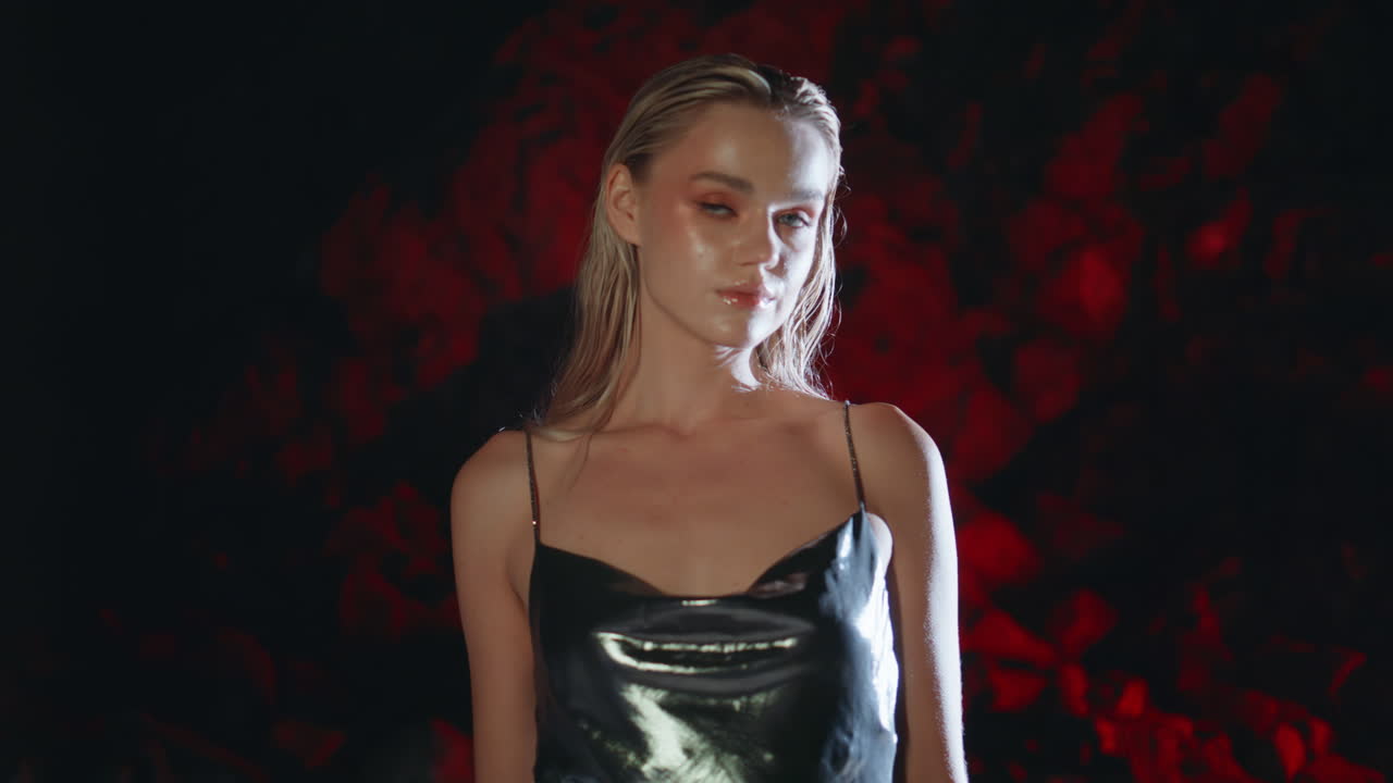 프로 모델이 야간 해안 바위에서 포즈를 취하고 있습니다. 프로젝트 라이트에서 멋진 소녀