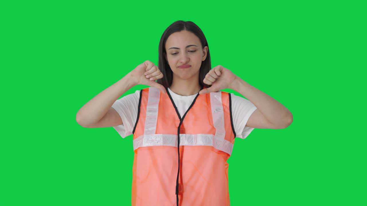 chica del personal de tierra del aeropuerto indio decepcionada mostrando los pulgares hacia abajo pantalla verde