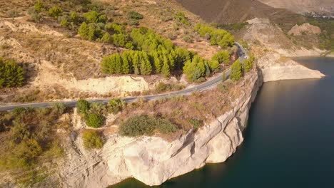 Vista-Aérea-De-Una-Carretera-Cerca-De-Una-Presa-En-El-Sur-De-España-En-Un-Día-De-Verano