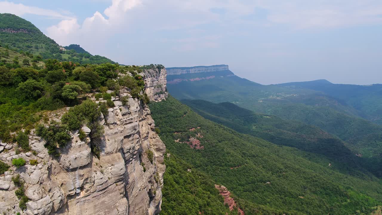 Flying over the beautiful rocky mountains and lush, green landscape of Catalunya, Spain - Aerial shot