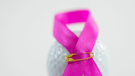 animación de cinta rosa, alfiler de seguridad y pelota de golf sobre fondo blanco