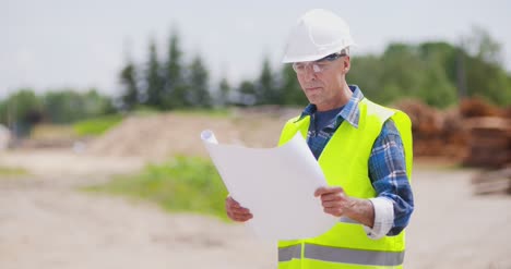 Selbstbewusster-Reifer-Männlicher-Ingenieur,-Der-Blaupause-Analysiert-3