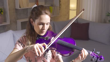 talented musician woman playing violin in living room at home.