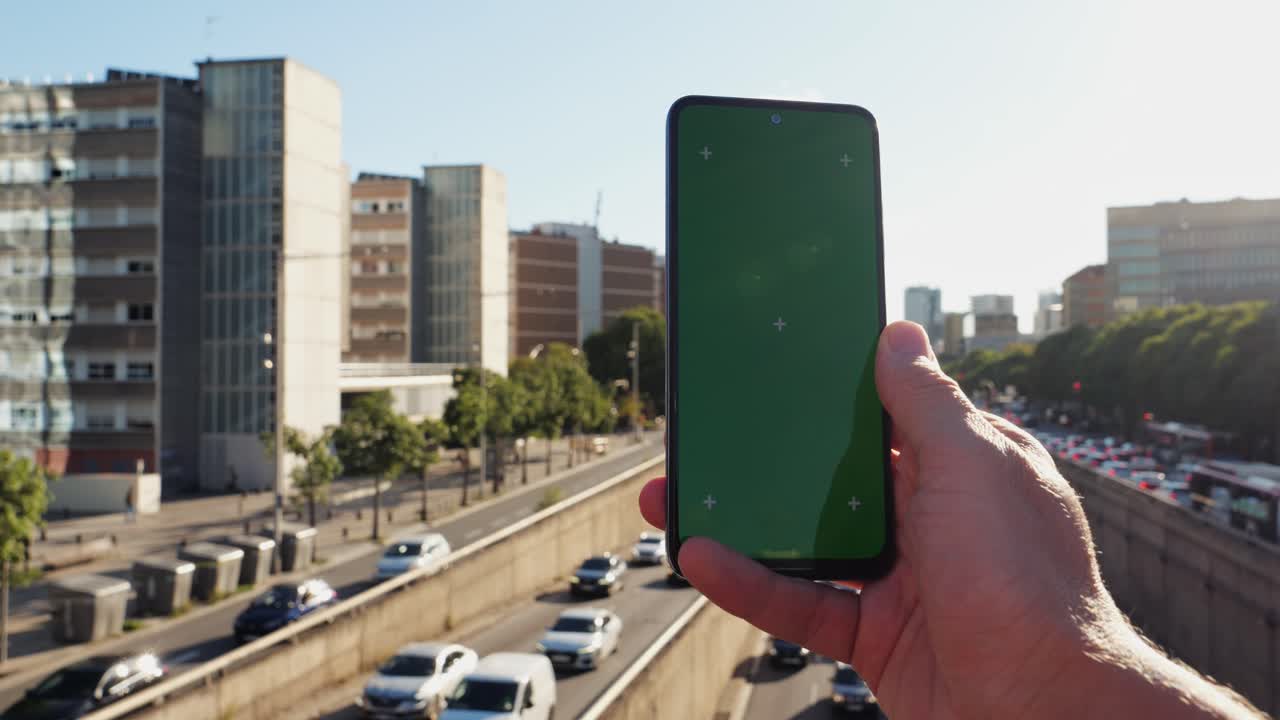 Smartphone with green screen in urban setting