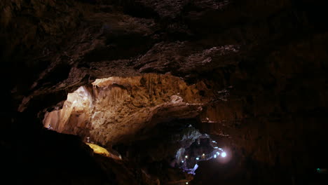 a vast underground cavern with rugged rock formations and a winding path below