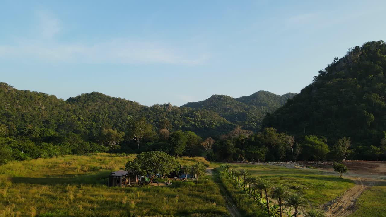 Aerial footage towards the hills and blue sky also revealing a flower park in Khao Yai, Pak Chong, Thailand