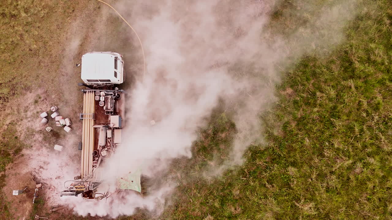 굴착 기기가 야외에서 활발하게 작동하여 위쪽에서 공기에 먼지를 방출합니다.