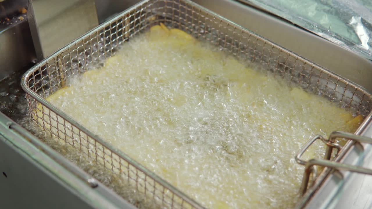 patatas fritas fritas en una freidora comercial