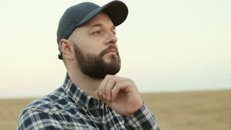 Portrait-shot-of-farmer-wearing-a-baseball-cap-and-thinking-about-something