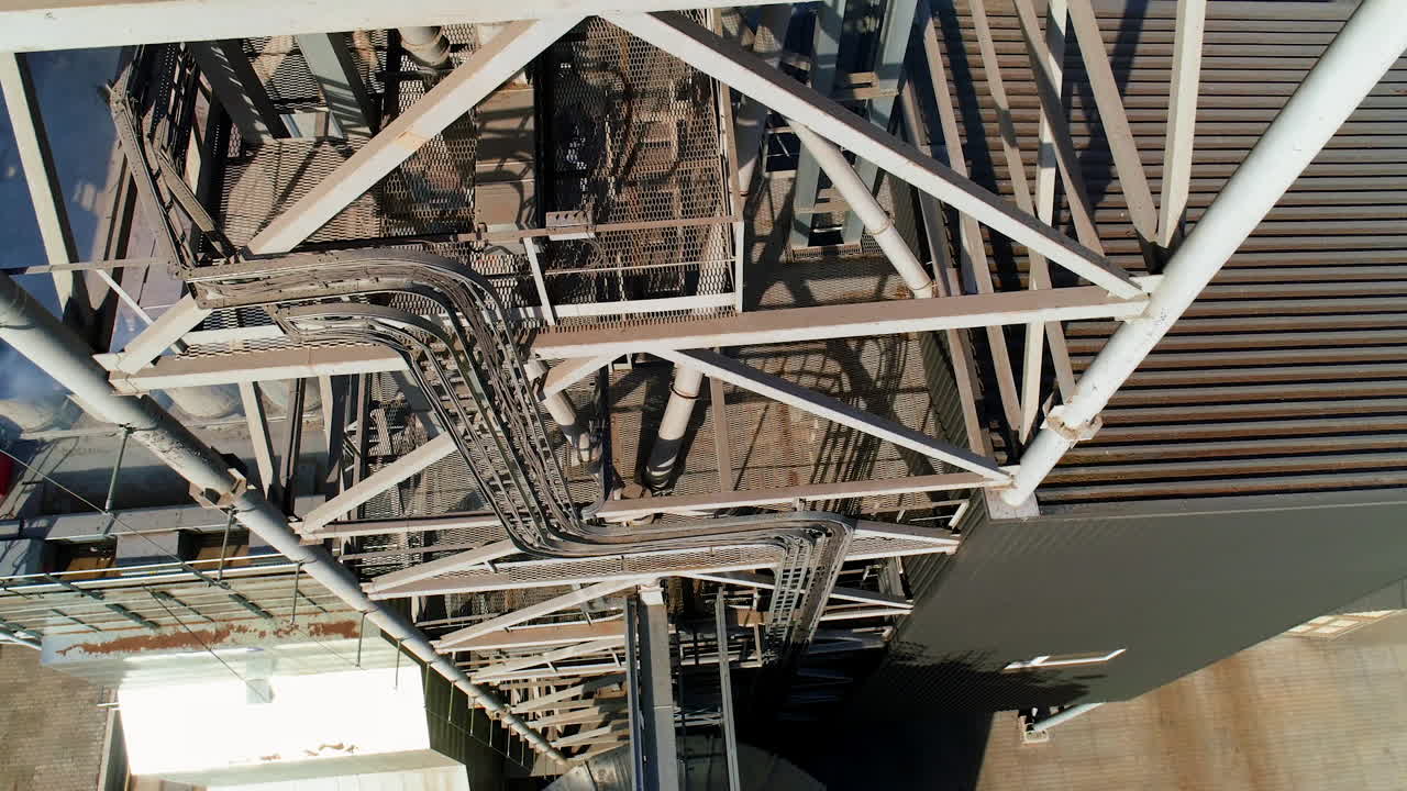 Modern metal grain elevator on field. Granary for storing and processing agricultural crop. Aerial view.