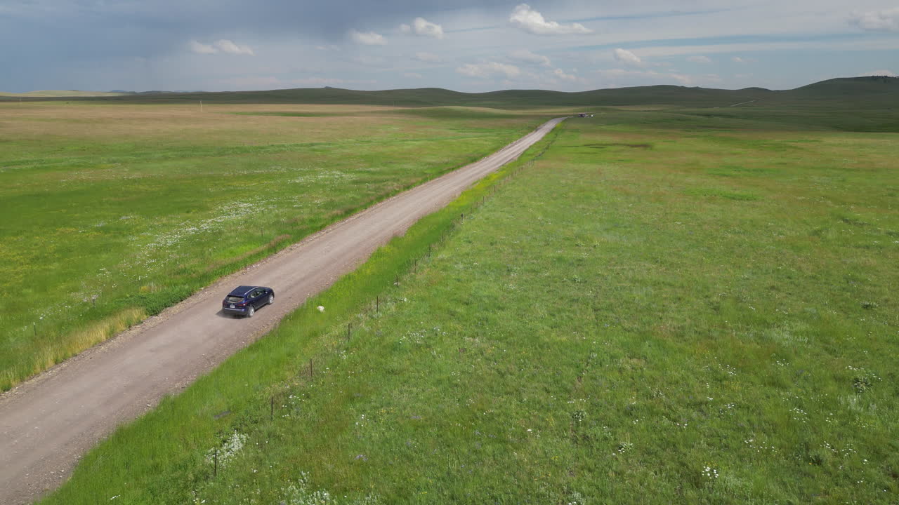 파란 suv 자동차가 시골의  ⁇ 길을 달리고 있습니다.