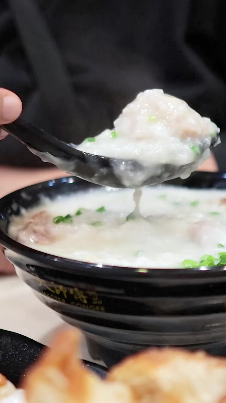 Close-up Seseorang Mengaduk dan Menyendok Bubur Panas.