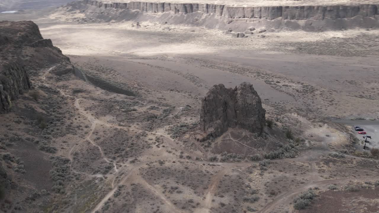 Slow aerial orbit of a large rock formation revealing Frenchman's Coulee State Park, WA