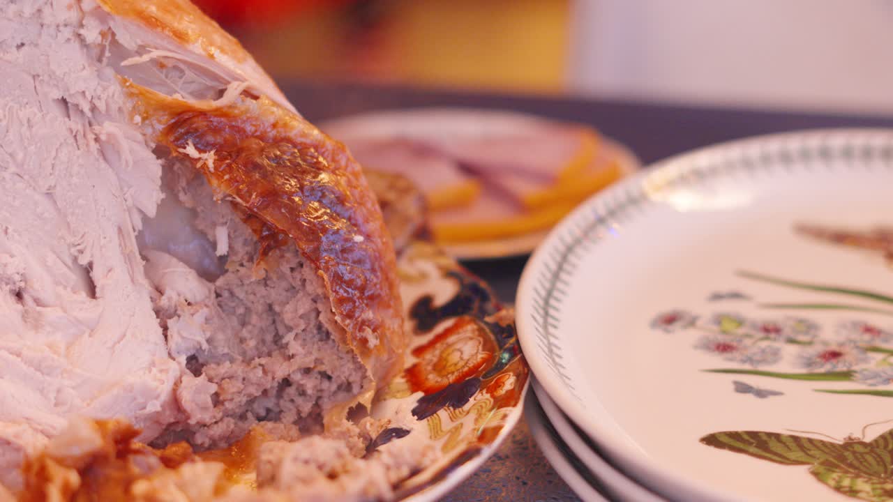 칠면조가 테이블 위에 쉬고 있는 크리스마스 저녁 장면, 배경에는 으로 구운 햄 슬라이스가 그려져 있다.